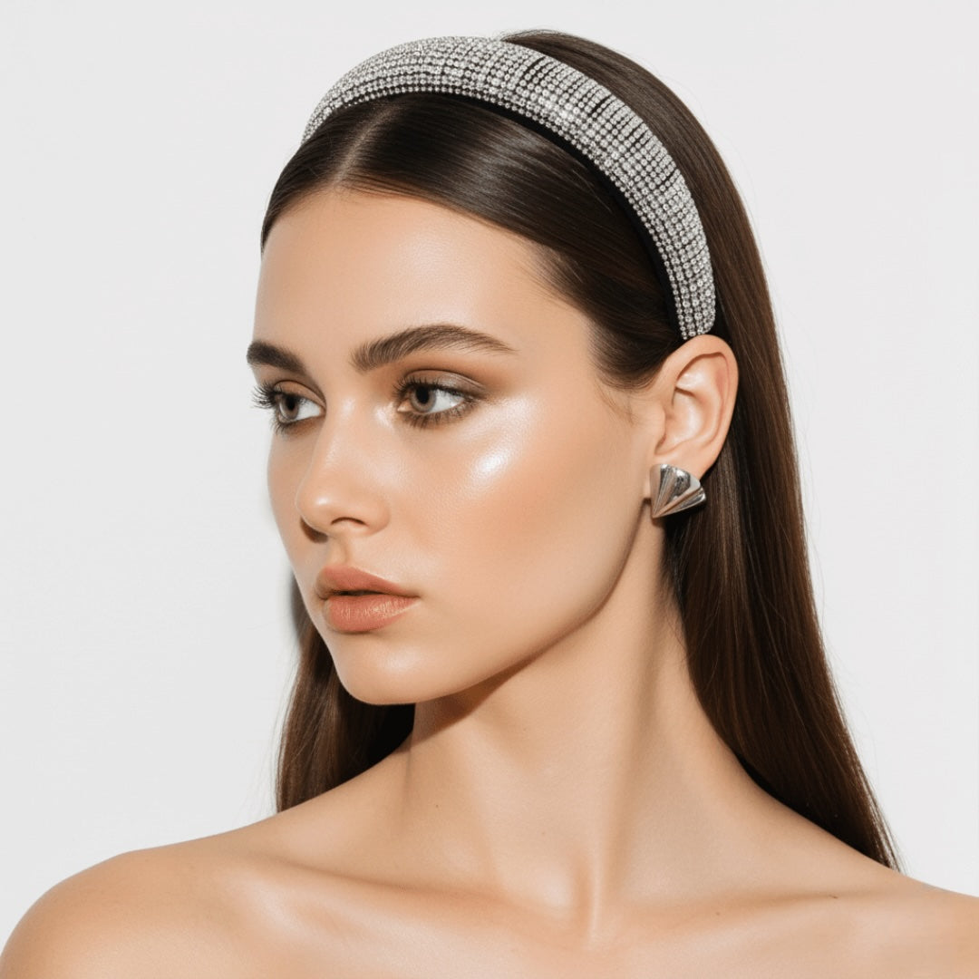 Woman wearing a decorative headband , VINTARAS BAROQUE RHINESTONE HEADBAND ,and vintage earrings with a plain background