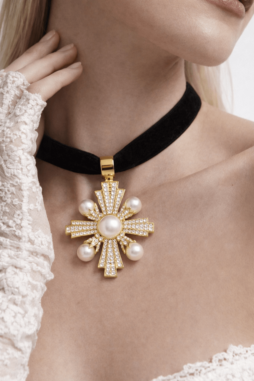 Cross-shaped pendant featuring pearls and small crystals on a black velvet necklace