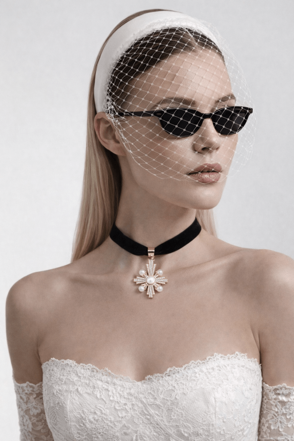 Cross-shaped pendant featuring pearls and small crystals on a black velvet necklace