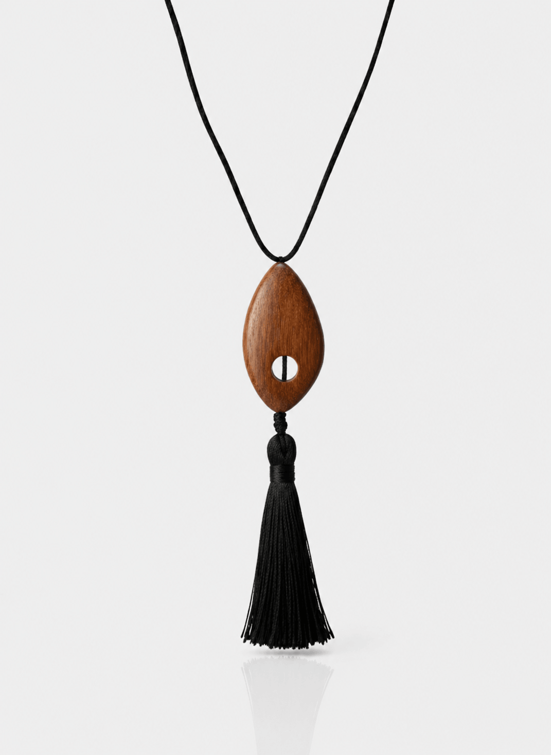 Wooden pendant necklace with black tassel on a white background