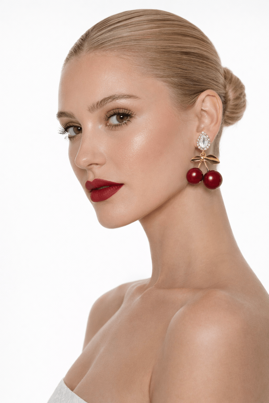 Woman wearing red berry earrings with a white background