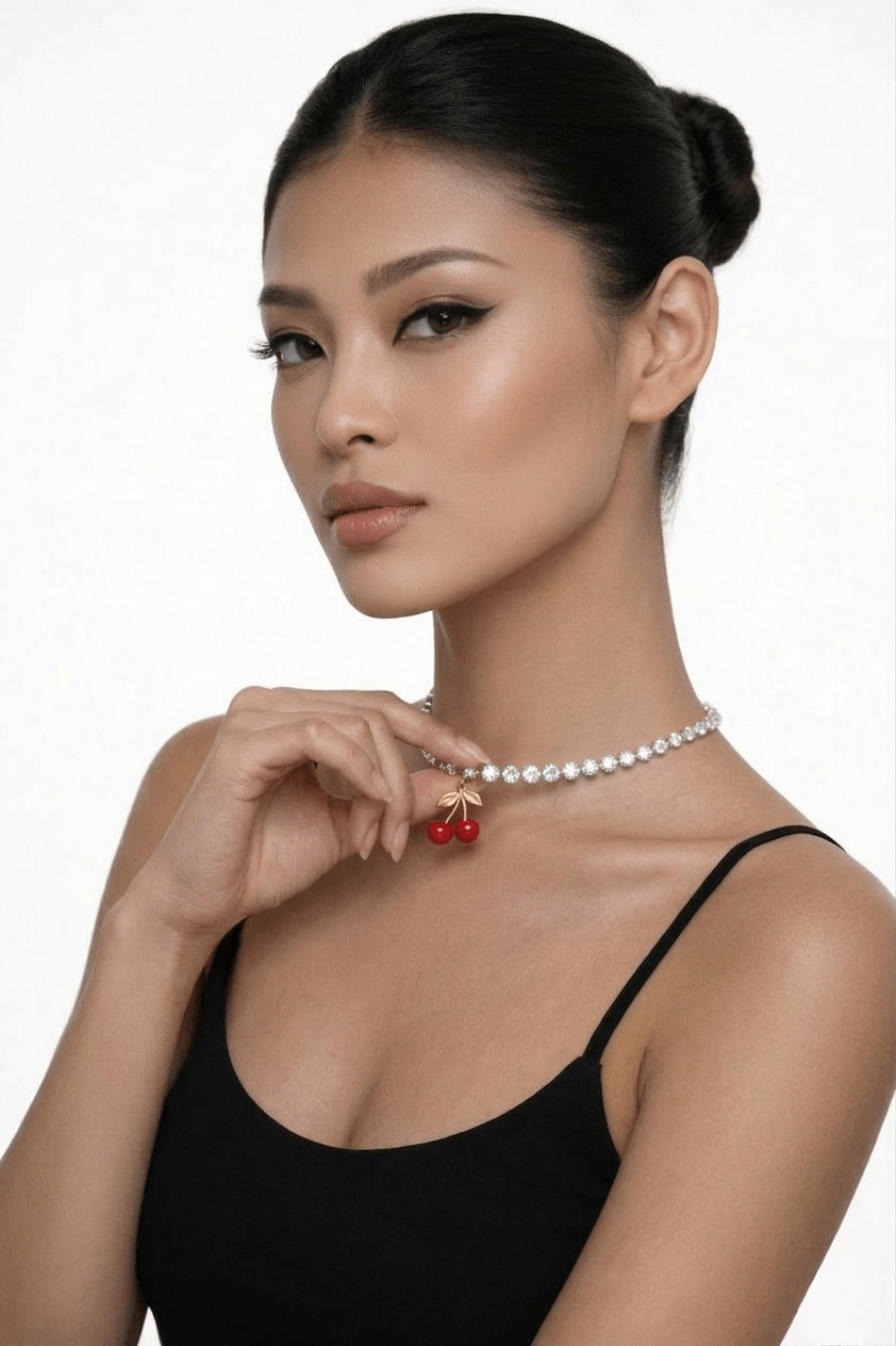 Woman wearing a tennis necklace with red cherry pendants on a white background