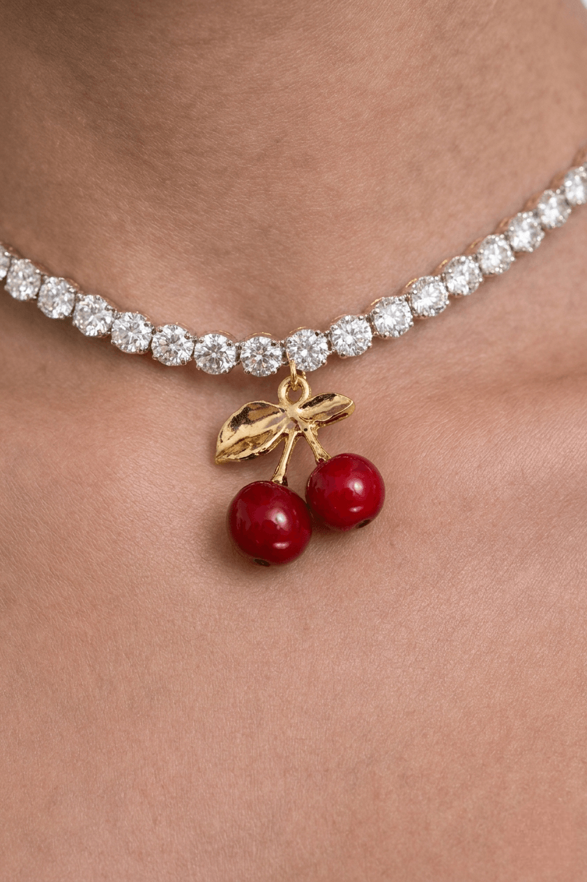 Tennis necklace with cherry pendant on a person's neck