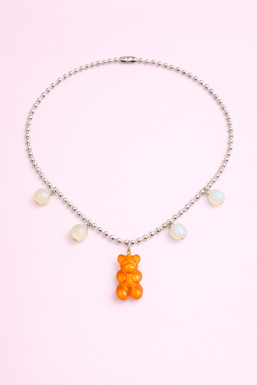 Dolce Bear Necklace with a gummy bear pendant on a pink background