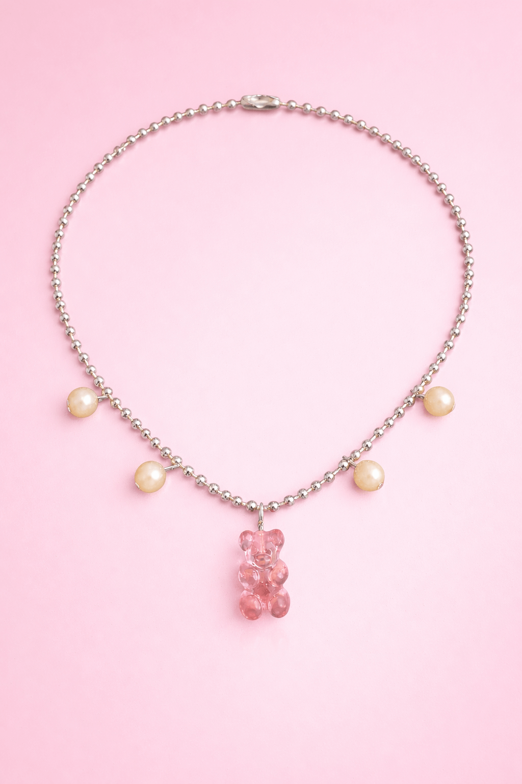 Dolce Bear Necklace with a pink gummy bear charm on a pink background