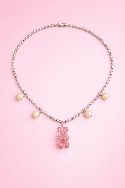 Dolce Bear Necklace with a pink gummy bear charm on a pink background