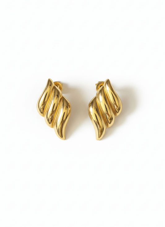 Pair of gold sculptural wave-shaped stud earrings on a white background