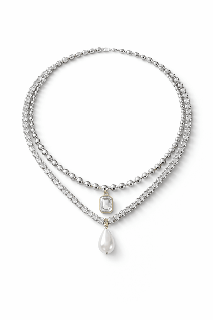 Layered necklaces, including a zirconia tennis necklace with a pearl pendant and ball chain necklace with zirconia pendant on a red background, Josephine Necklace Set by Vintaras.