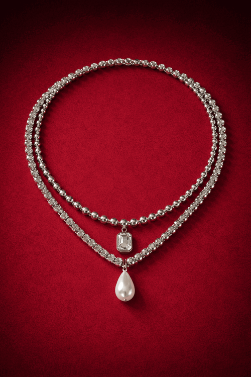 Necklaces layered,  including a zirconia tennis necklace with a pearl pendant and ball chain necklace with zirconia pendant on a red background, Josephine Necklace Set by Vintaras.