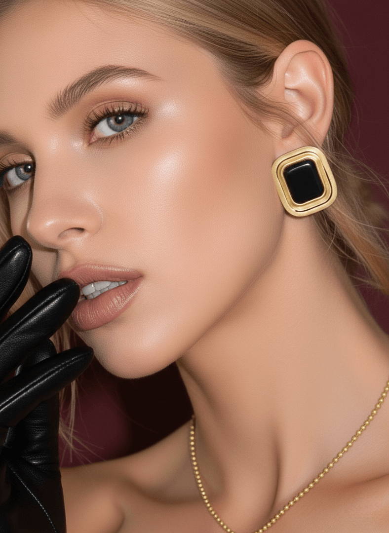 A woman wears Laila black agate cabochon earrings .