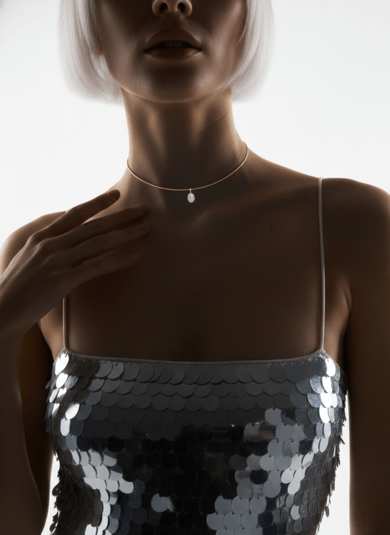 Woman wearing a sequin dress and Vintaras Mila Gold cuff necklace with a zirconia pendant against a neutral background