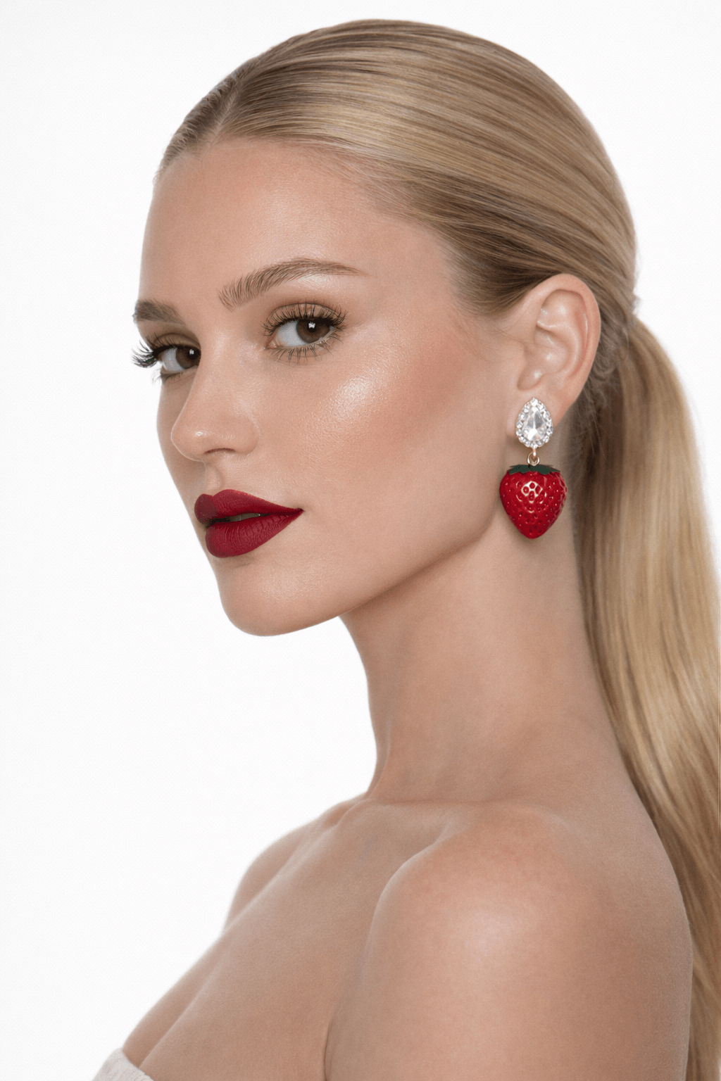 Woman wearing strawberry-shaped earrings on a white background