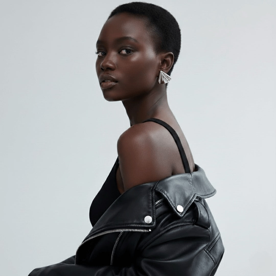 Model wearing Vintaras Solis Earring in silver and a black leather jacket on a light gray background