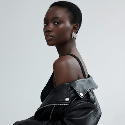 Model wearing Vintaras Solis Earring in silver and a black leather jacket on a light gray background