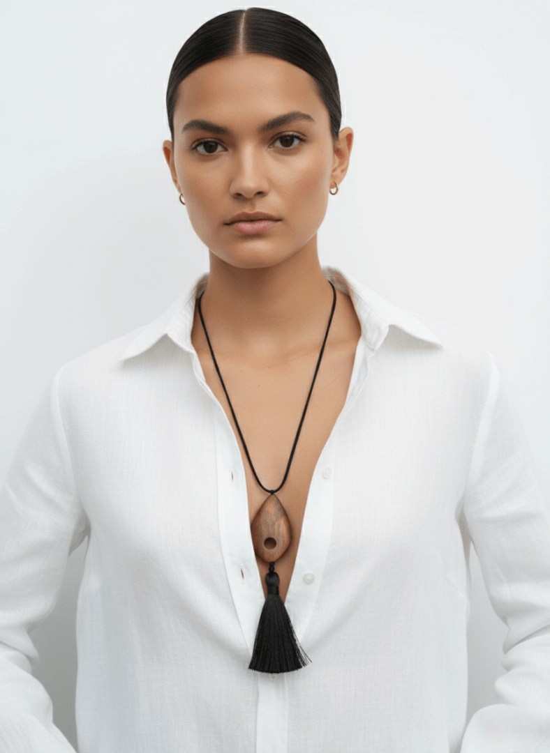 Woman wearing a white shirt with a Vintaras Bette Tassel Necklace on a plain background