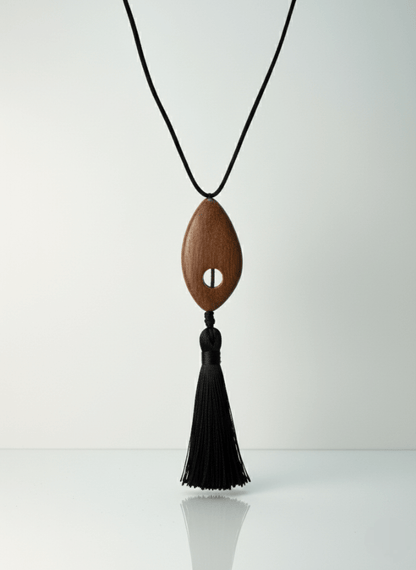 Bette tassel necklace, Wooden pendant necklace with a black tassel on a white background.