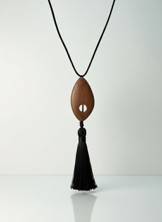 Bette tassel necklace, Wooden pendant necklace with a black tassel on a white background.