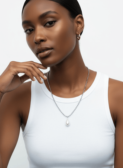 Woman wearing a white tank top and Vintaras Ingrid necklace in silver against a plain background