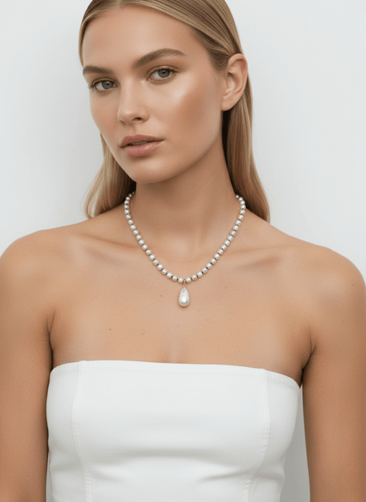 Woman wearing a vintage pearl necklace, Vintaras Rita Pearl Necklace , against a plain background