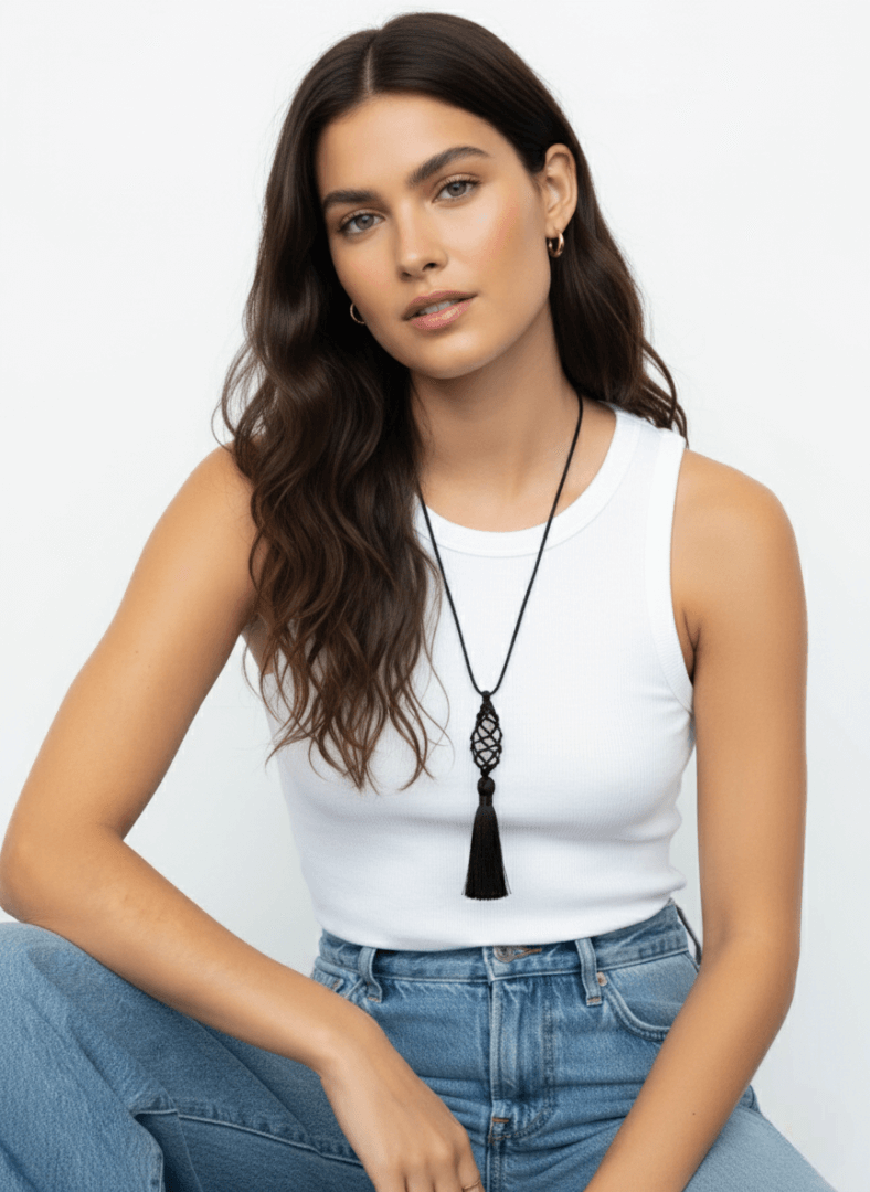 Woman wearing a white tank top and blue jeans with a black tassel necklace , Vintaras Vivien Tassel Necklace, against a light gray background