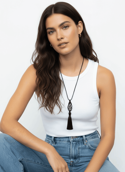 Woman wearing a white tank top and blue jeans with a black tassel necklace , Vintaras Vivien Tassel Necklace, against a light gray background