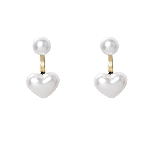 Heart-shaped earrings with pearl tops on a white background
